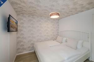 アールベックにあるAhlbeck Remise Uppsalaの白いベッドとテレビが備わる小さな客室です。