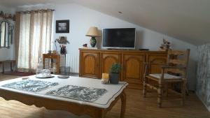 a living room with a table and a tv at Chambre d'hôtes de Marie in Chémery