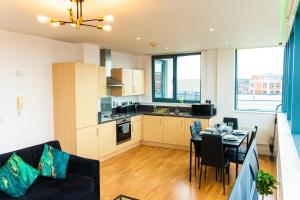 eine Küche und ein Wohnzimmer mit einem Tisch und einem Sofa in der Unterkunft The Regency Suite - Modern 2-Bed 1-Bath Apartment in Chertsey