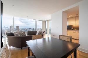 a kitchen and dining room with a table and chairs at Borough Flat with City Views by UnderTheDoormat in London