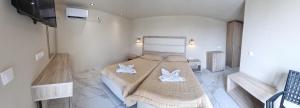 sypialnia z łóżkiem z ręcznikami w obiekcie The Blue Sea Hotel w mieście Agios Georgios