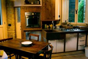a kitchen with a table and a stove top oven at La casina-Maisonette in Serramazzoni