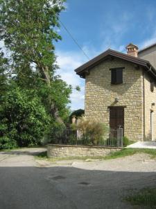 a small brick building with a gate and a fence at La casina-Maisonette in Serramazzoni