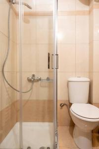 ein Bad mit einem WC und einer Glasdusche in der Unterkunft Lovebirds Nest 1BR Apt. 7' to Acropolis Metro in Athen