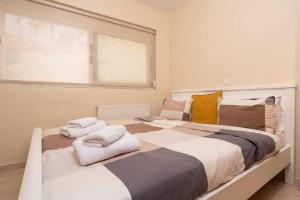ein Schlafzimmer mit 2 Betten und Handtüchern darauf in der Unterkunft Lovebirds Nest 1BR Apt. 7' to Acropolis Metro in Athen