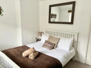 1 cama blanca con 2 almohadas y espejo en Afan Forest House - Private doubles or Twin options! Perfect for Contractors! en Port Talbot