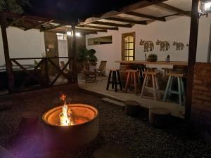 a fire pit in the middle of a room with a bar at Hostal Casa Encino in Santa Cruz