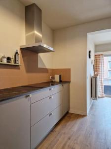 a kitchen with white cabinets and a stove top oven at Gezellig appartement in Vilvoorde in Vilvoorde