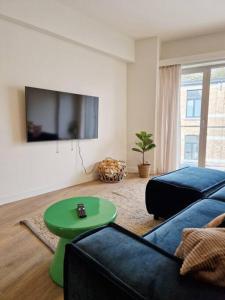 een woonkamer met een bank en een groene tafel bij Gezellig appartement in Vilvoorde in Vilvoorde