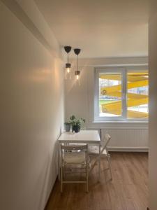 een tafel en stoelen in een kamer met een raam bij White apartment in Kėdainiai
