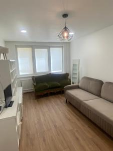 uma sala de estar com um sofá e uma televisão em White apartment em Kėdainiai