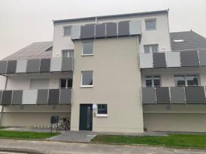 un edificio bianco con molte finestre di Stadtoase Wohnträumerei- Moderne Design Wohnung mit Ruhegarantie und gemütlichem Kamin in urbanem Ambiente a Paderborn