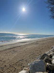 - une plage avec des rochers et le soleil dans le ciel dans l'établissement vista mare, à Pineto