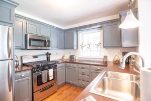 une cuisine avec des armoires bleues et des appareils en acier inoxydable dans l'établissement The Wayside Cottage, à Nashville 18 autres photos
