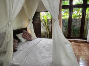 um quarto com uma cama e uma rede mosquiteira em Enchanting Two Bedroom Villa With Private Pool em Ubud