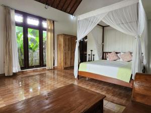 um quarto com uma cama e uma grande janela em Enchanting Two Bedroom Villa With Private Pool em Ubud
