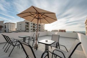 un patio avec des tables et des chaises ainsi qu'un parasol sur le toit dans l'établissement Vacanza, à Bar