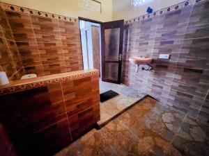 uma casa de banho com um chuveiro, um lavatório e uma banheira em Enchanting Two Bedroom Villa With Private Pool em Ubud