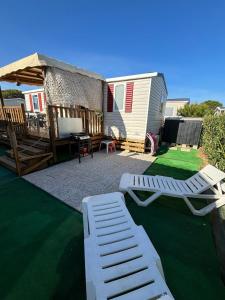 a backyard with a tent and two lounge chairs at Mobil home 6 à 8 personnes SANS Fun Pass in Canet-en-Roussillon