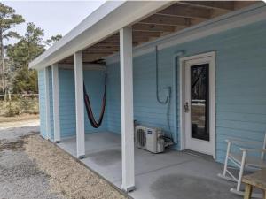 a front porch of a blue house with a door at Cozy studio with movie theater, beach 5 min away in Morehead City