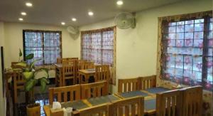 ein leeres Klassenzimmer mit Tischen, Stühlen und Fenstern in der Unterkunft Hotel Suite Inn Lodge in Pokhara