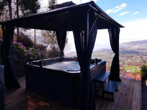 un bain à remous avec un auvent sur une terrasse en bois dans l'établissement Elvira House Montreux, un lieu magique !, à Montreux