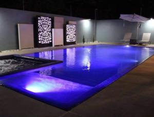 uma grande piscina com iluminação azul num quarto em Stylish Condo In Tribeca em San Pedro Sula
