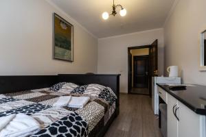 um quarto com uma cama com um edredão preto e branco em Алексік em Truskavets