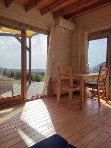Zimmer mit einem Holztisch und Stühlen auf einer Veranda in der Unterkunft Petirrojo in Vejer de la Frontera