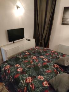 um quarto com uma cama com um cobertor florido em Appartement Fizu em El Serrat