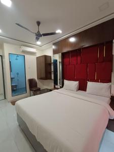 a bedroom with a large white bed with a red headboard at AR Residency in Mumbai +25 photos