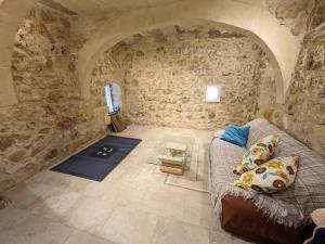 sala de estar con sofá en una pared de piedra en PERLA 21, en Żebbuġ