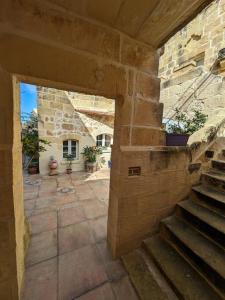 vistas al exterior de un edificio de piedra con una escalera en PERLA 21, en Żebbuġ