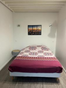 - une chambre avec un lit doté d'un couvre-lit rouge dans l'établissement Villa Camelia Rueil malmaison métropole grand Paris, à Rueil-Malmaison