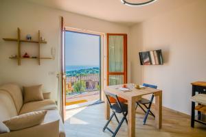 a living room with a table and a couch and a window at Casa Sestini in Capoliveri