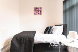 a bedroom with a bed with a black headboard at Farnworth Contractor Accommodation in Farnworth