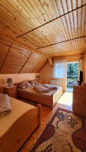 Cette grande chambre dispose de deux lits et d'un plafond en bois. dans l'établissement Casa de vacanta Julius, à Padis