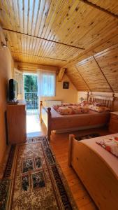 1 dormitorio con 2 camas y techo de madera en Casa de vacanta Julius, en Padis