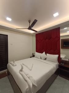 a bedroom with a large bed with a red headboard at AR Residency in Mumbai