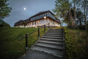 ein Gebäude auf einem Hügel mit einer Treppe davor in der Unterkunft Sonnenhotel Feldberg am See mit Schwimmbad, Sauna und Dampfbad in Feldberg