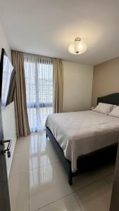1 dormitorio con cama y ventana grande en Stylish Condo In Tribeca en San Pedro Sula