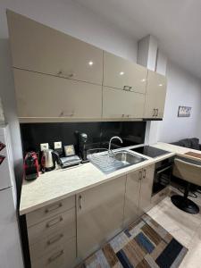 a kitchen with white cabinets and a sink at Studio One in Kanálion