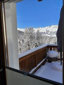 balcón con vistas a las montañas nevadas en Chesa Vista Mezdi 6 Bergbahnen Sommer und ÖV inklusive en Pontresina