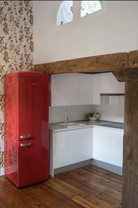 a red refrigerator in a kitchen with white cabinets at IAROS SOL in Santander