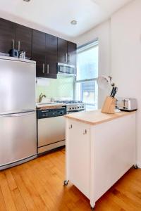 a kitchen with stainless steel appliances and wooden floors at Stylish and Cozy 2BD apartment in New York