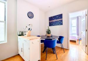 a dining room with a table and blue chairs at Stylish and Cozy 2BD apartment in New York