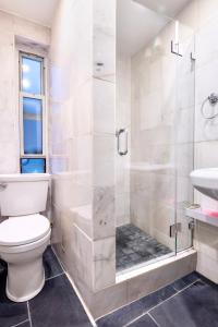 a bathroom with a shower and a toilet and a sink at Stylish and Cozy 2BD apartment in New York