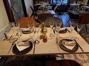 drewniany stół z okularami i serwetkami w obiekcie Au Coeur d'Alle w Alle