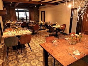 uma sala de jantar com mesas e cadeiras num restaurante em Au Coeur d'Alle em Alle