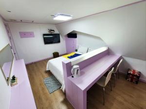 Cette petite chambre comprend un lit, une table et des chaises. dans l'établissement Residence Yeoyu, à Guri